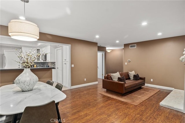 living room with wood finished floors, recessed lighting, and baseboards