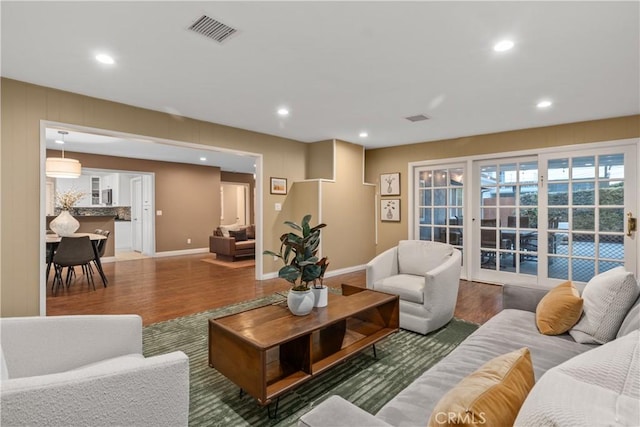 living room featuring wood finished floors, recessed lighting, and baseboards