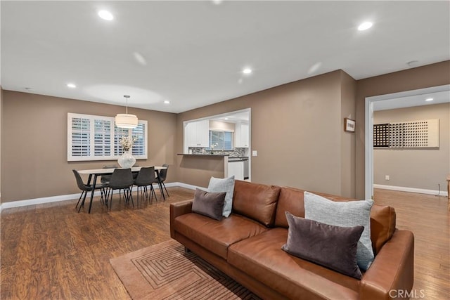 living room with wood finished floors, baseboards, and recessed lighting