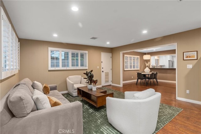 living area with wood finished floors, baseboards, and recessed lighting