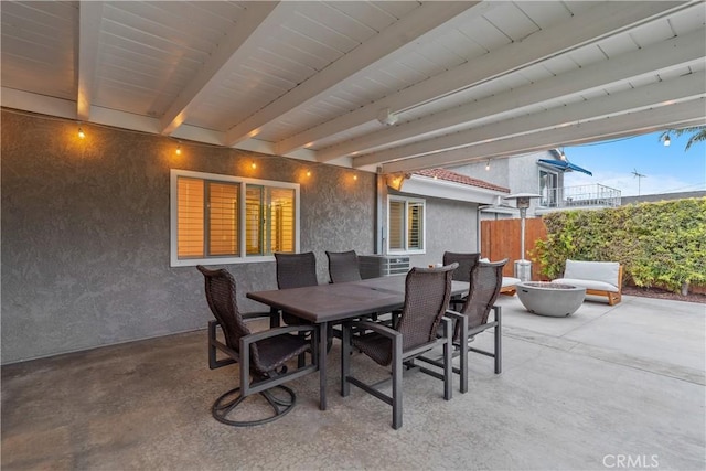 view of patio / terrace featuring fence, a fire pit, and outdoor dining area