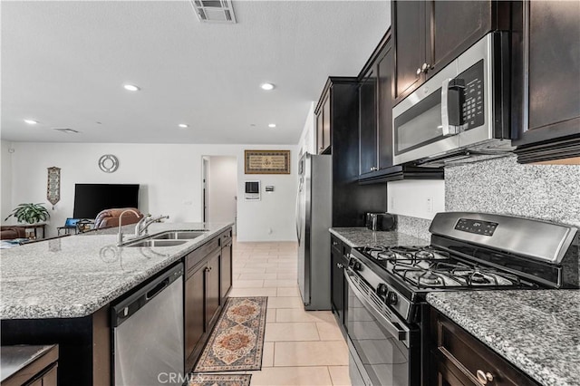 37732 Phelan Ln, Palmdale, CA 93552 - kitchen with appliances with stainless steel finishes, a sink, light stone counters, open floor plan, and recessed lighting