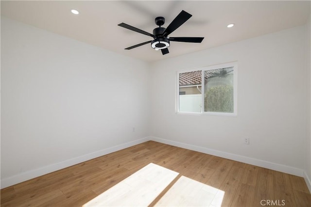 spare room with baseboards, light wood-type flooring, recessed lighting, and a ceiling fan