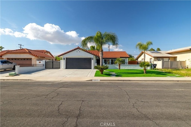 mediterranean / spanish-style home featuring an attached garage, a gate, driveway, and a tiled roof