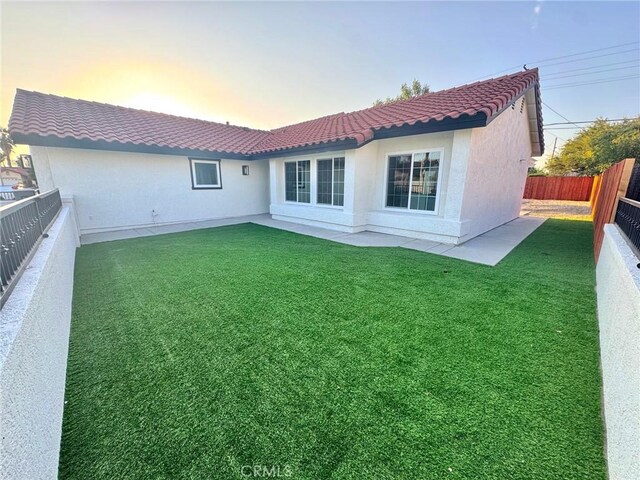 rear view of property featuring a tile roof and stucco siding