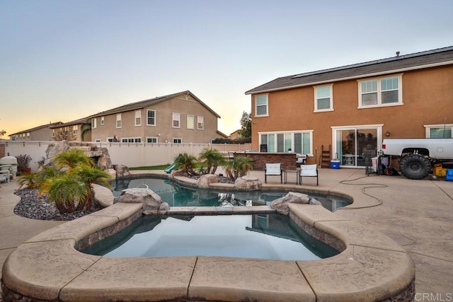view of swimming pool with a fenced backyard, a patio area, and a pool with connected hot tub