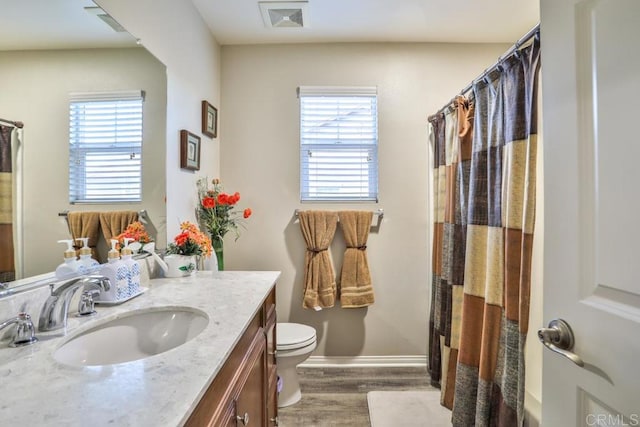 bathroom featuring wood finished floors, toilet, vanity, baseboards, and a shower with shower curtain