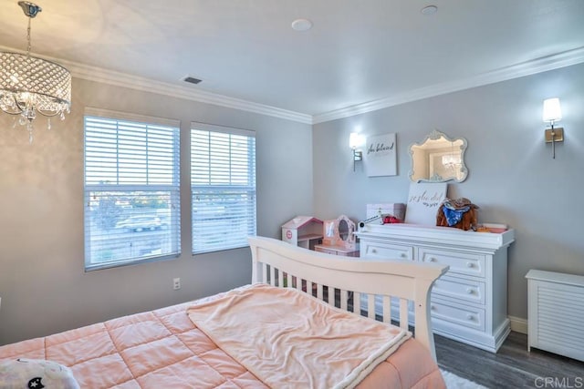 bedroom with a chandelier, dark wood finished floors, ornamental molding, and baseboards