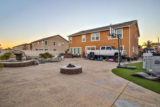 back of house featuring an outdoor fire pit, stucco siding, a patio, and fence