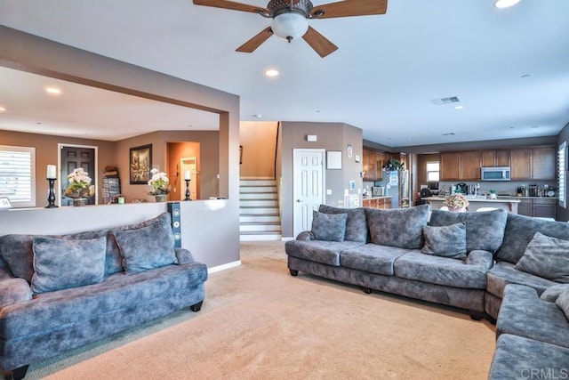 living area with light colored carpet, stairs, recessed lighting, ceiling fan, and baseboards