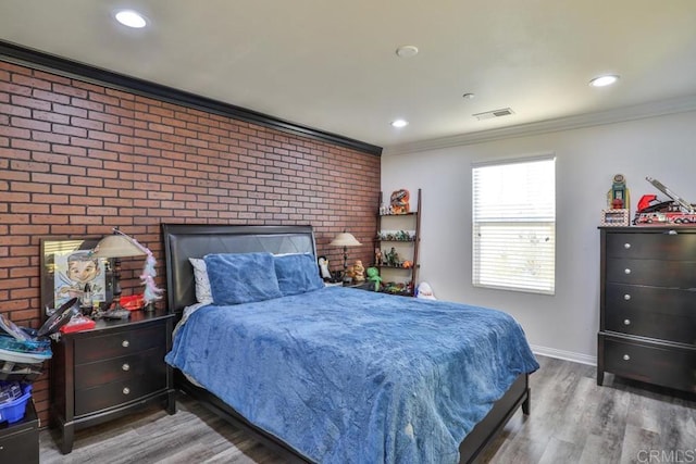bedroom with ornamental molding, wood finished floors, brick wall, baseboards, and recessed lighting