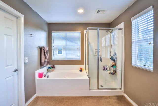 bathroom featuring a stall shower, a bath, and baseboards