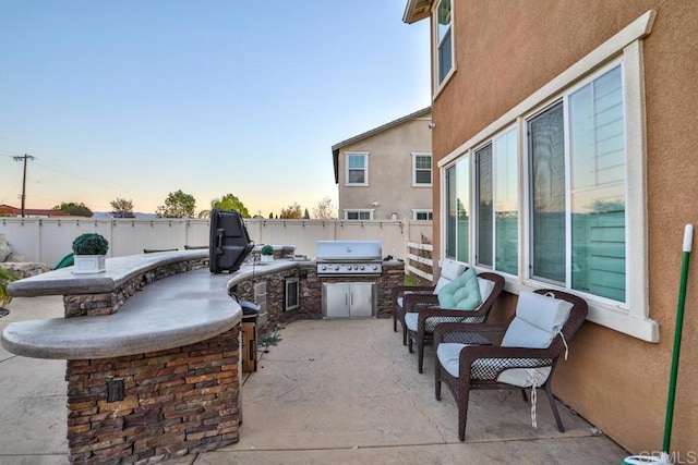 view of patio / terrace with a grill, exterior kitchen, and a fenced backyard