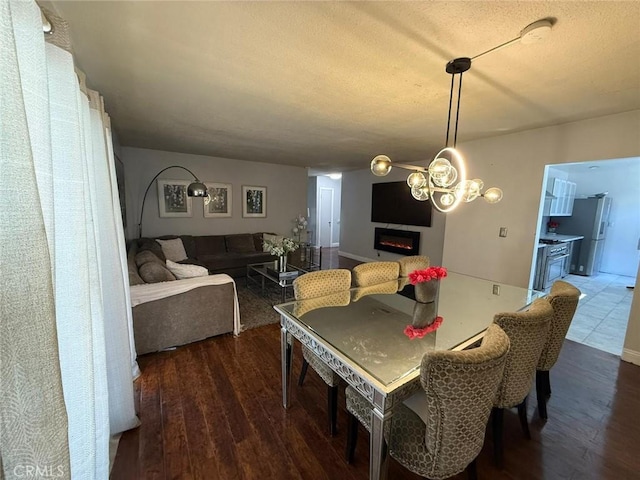 9617 Greenwood Ave, Montclair, CA 91763 - dining room featuring a lit fireplace, dark wood-style floors, and a textured ceiling