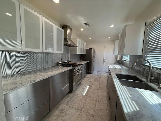 9617 Greenwood Ave, Montclair, CA 91763 - kitchen with wall chimney exhaust hood, stainless steel appliances, a sink, backsplash, and glass insert cabinets
