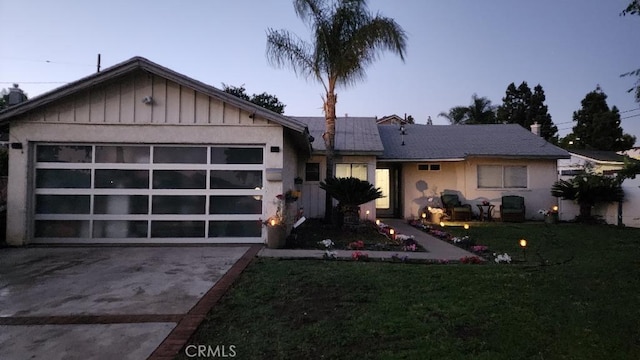 9617 Greenwood Ave, Montclair, CA 91763 - view of front of house with driveway, a front lawn, board and batten siding, and an attached garage