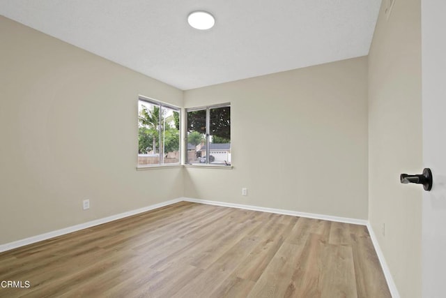 empty room featuring baseboards and wood finished floors