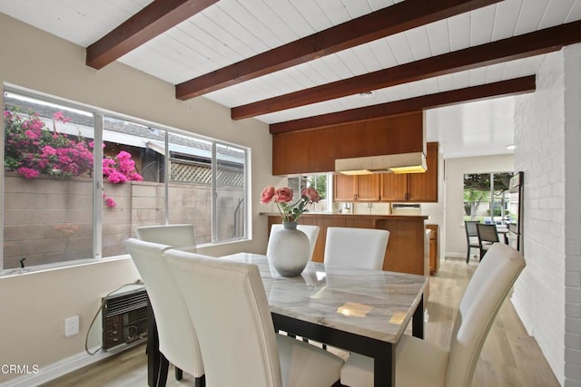 dining area featuring beamed ceiling, light wood-type flooring, wood ceiling, and baseboards