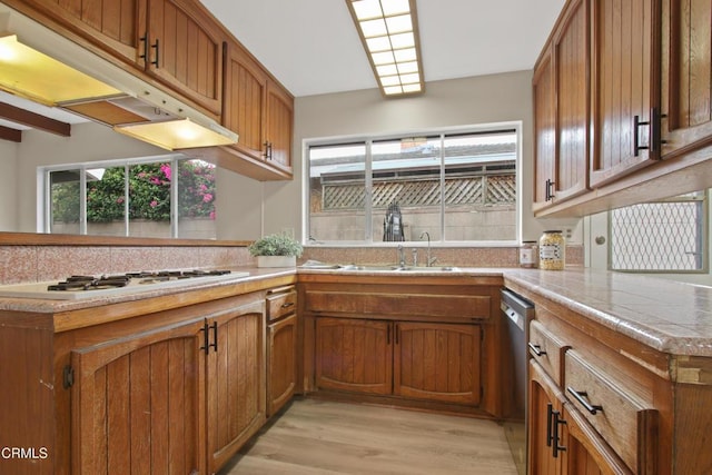 kitchen with white gas stovetop, tasteful backsplash, brown cabinetry, and stainless steel dishwasher