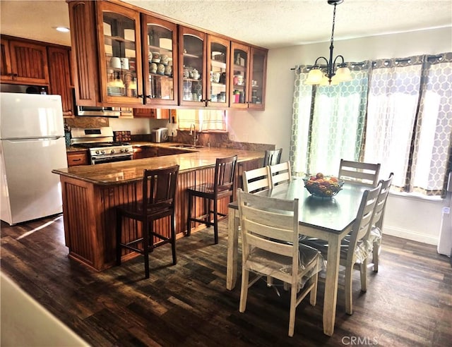 8149 Langdon Ave, Hesperia, CA 92345 - dining room with a textured ceiling, dark wood-style flooring, and a chandelier