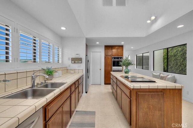 1467 18th St, Manhattan Beach, CA 90266 - kitchen with appliances with stainless steel finishes, tile countertops, a sink, recessed lighting, and brown cabinets