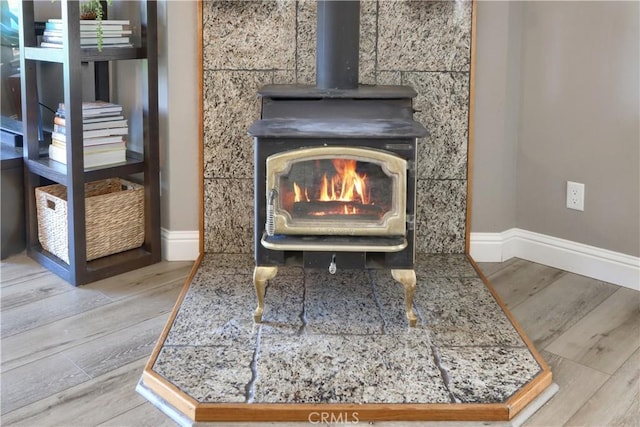 45792 Sutton Dr, Oakhurst, CA 93644 - detailed view of a wood stove, baseboards, and wood finished floors