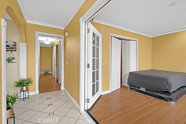 4340 Highland Ave, Oxnard, CA 93033 - hall featuring a textured ceiling, arched walkways, crown molding, baseboards, and light tile patterned floors