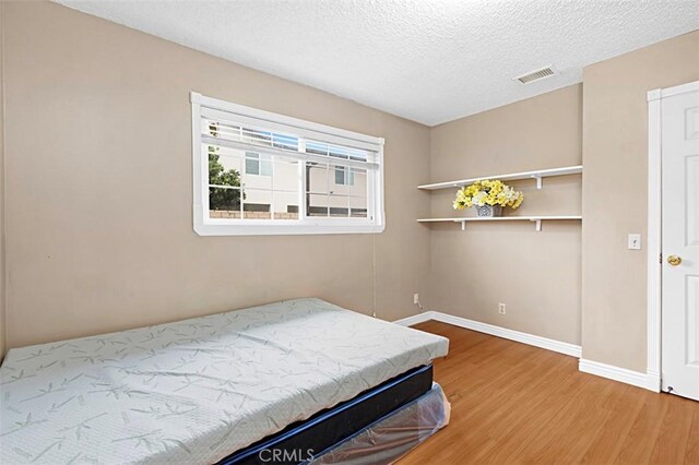 4340 Highland Ave, Oxnard, CA 93033 - bedroom with light wood-type flooring, baseboards, and a textured ceiling