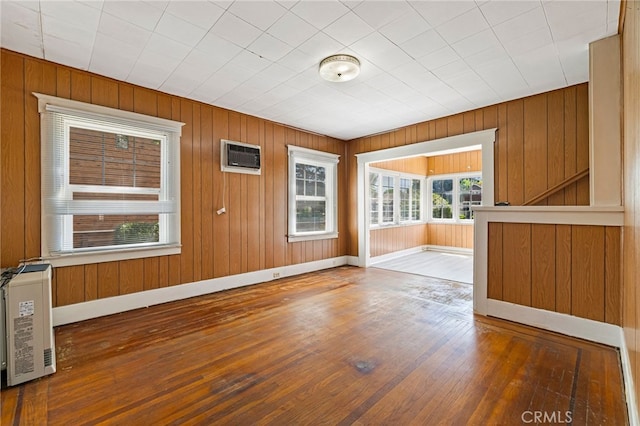 440 S Plumas St, Willows, CA 95988 - unfurnished dining area with wood-type flooring, baseboards, a wall mounted air conditioner, and wood walls