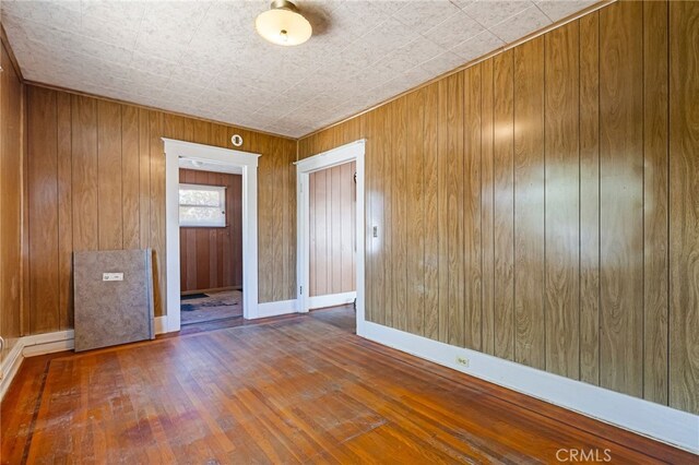 440 S Plumas St, Willows, CA 95988 - empty room featuring wood finished floors, wood walls, and baseboards