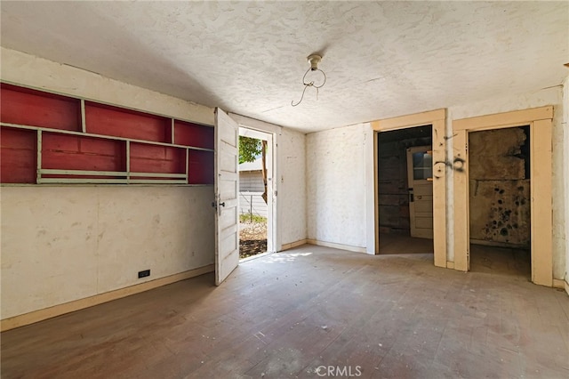 440 S Plumas St, Willows, CA 95988 - unfurnished bedroom featuring access to exterior, wood finished floors, a textured ceiling, and baseboards