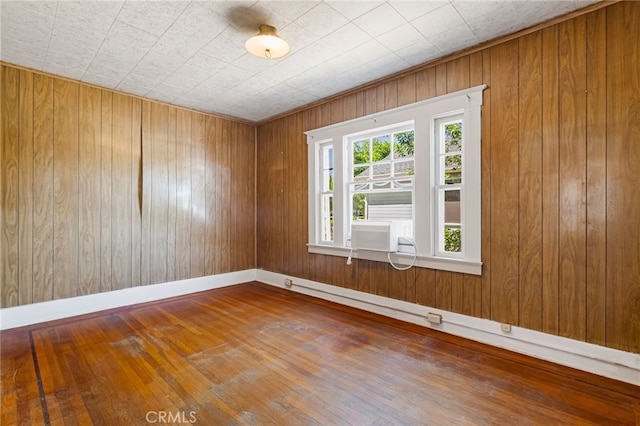 440 S Plumas St, Willows, CA 95988 - empty room featuring hardwood / wood-style floors, wood walls, cooling unit, and baseboards