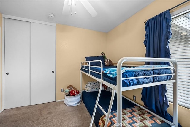 carpeted bedroom featuring ceiling fan and a closet