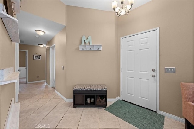 entryway with light tile patterned flooring and a chandelier