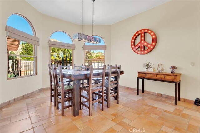 31024 Rabbit Springs Rd, Lucerne Valley, CA 92356 - dining room with stone tile flooring, healthy amount of natural light, baseboards, and a towering ceiling