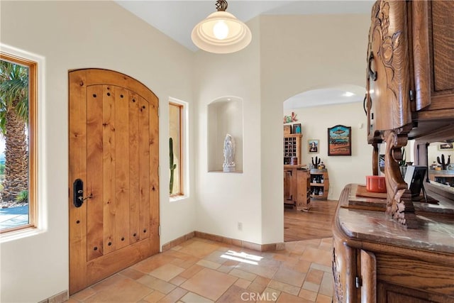 31024 Rabbit Springs Rd, Lucerne Valley, CA 92356 - foyer entrance with stone tile floors, arched walkways, healthy amount of natural light, and baseboards