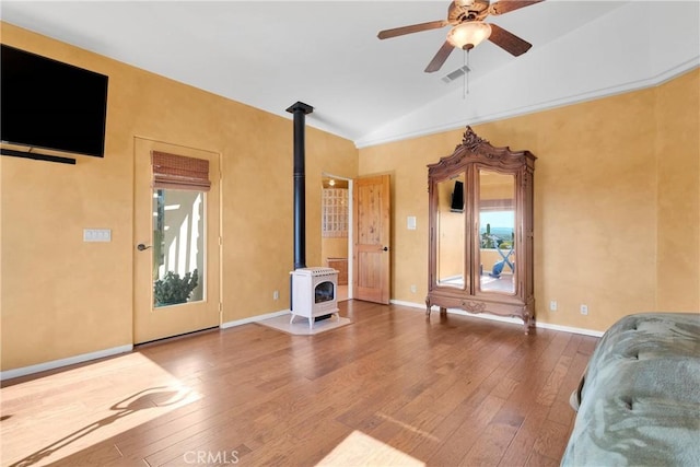 31024 Rabbit Springs Rd, Lucerne Valley, CA 92356 - interior space with a wood stove, vaulted ceiling, wood-type flooring, a ceiling fan, and baseboards