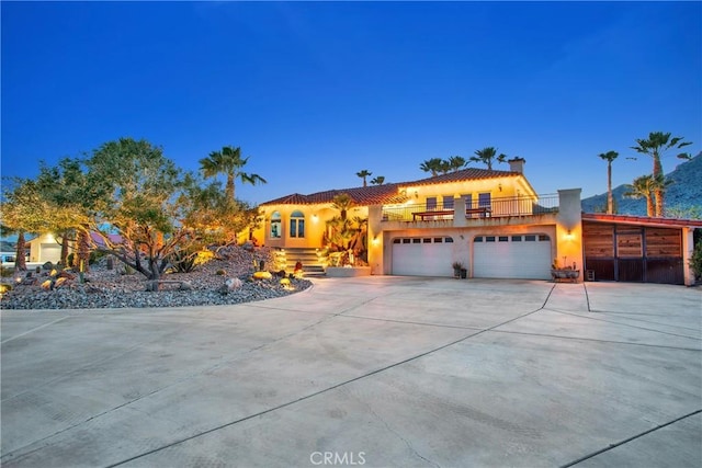 31024 Rabbit Springs Rd, Lucerne Valley, CA 92356 - mediterranean / spanish-style home featuring a garage, driveway, a tile roof, a chimney, and stucco siding