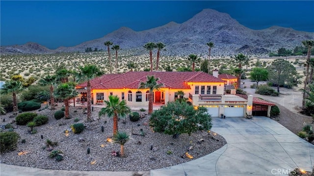 31024 Rabbit Springs Rd, Lucerne Valley, CA 92356 - view of front facade featuring a tiled roof, a mountain view, driveway, stucco siding, and a garage