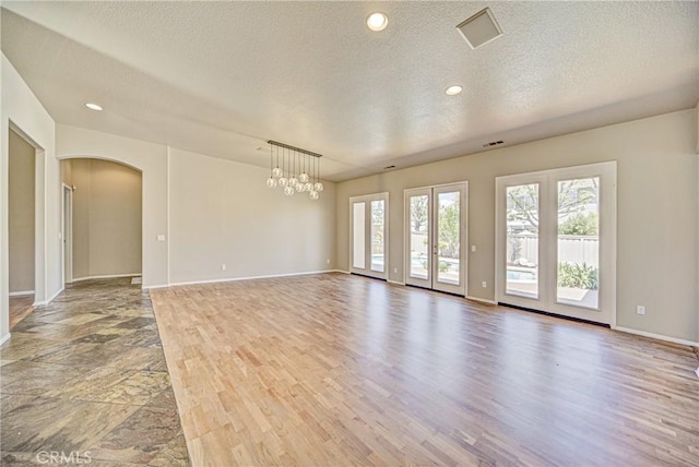 43922 Carentan Dr, Temecula, CA 92592 - empty room with arched walkways, a textured ceiling, wood finished floors, a chandelier, and recessed lighting