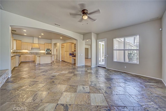 43922 Carentan Dr, Temecula, CA 92592 - unfurnished living room featuring ceiling fan, stone tile flooring, arched walkways, and recessed lighting