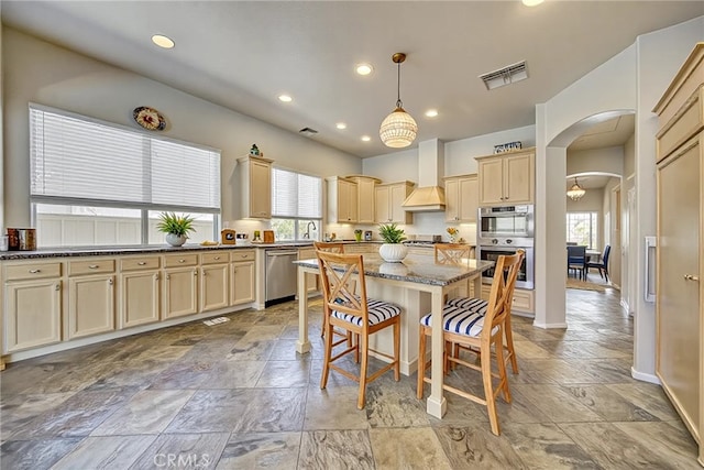 43922 Carentan Dr, Temecula, CA 92592 - kitchen featuring stainless steel appliances, arched walkways, a kitchen bar, stone tile flooring, and recessed lighting