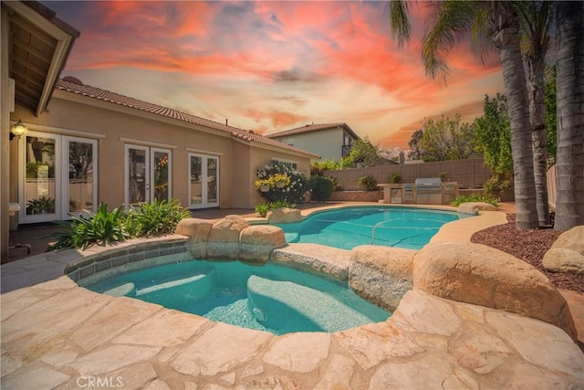 43922 Carentan Dr, Temecula, CA 92592 - pool at dusk with french doors, a patio, and a pool with connected hot tub