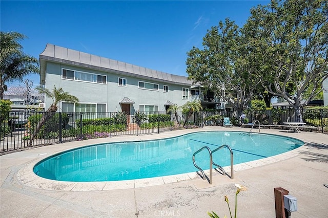community pool with fence and a patio