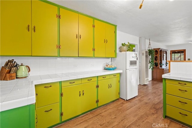 51609 Oregon Trl, Morongo Valley, CA 92256 - kitchen featuring freestanding refrigerator, backsplash, light wood-style floors, and tile counters