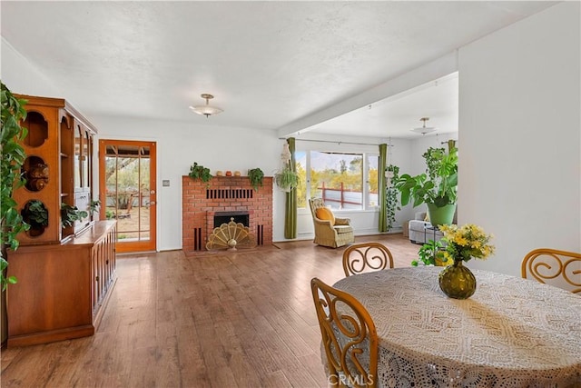 51609 Oregon Trl, Morongo Valley, CA 92256 - dining space with healthy amount of natural light, hardwood / wood-style floors, and a fireplace