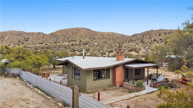 51609 Oregon Trl, Morongo Valley, CA 92256 - view of front of property featuring a chimney, fence, and a mountain view