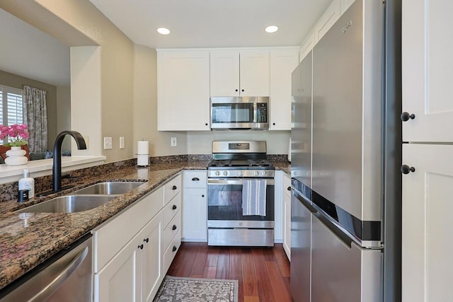 1825 Via Capri St, Chula Vista, CA 91913 - kitchen featuring stainless steel appliances, a sink, dark stone counters, dark wood-type flooring, and white cabinetry