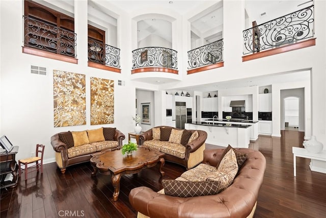 4448 St Cloud, Claremont, CA 91711 - living room with dark wood-style flooring, baseboards, a towering ceiling, and arched walkways