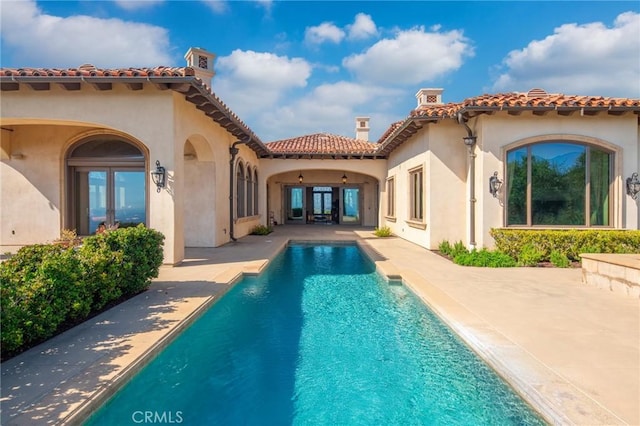 7811 Camino De Arriba, Rancho Santa Fe, CA 92067 - back of house featuring french doors, stucco siding, a patio area, an outdoor pool, and a chimney